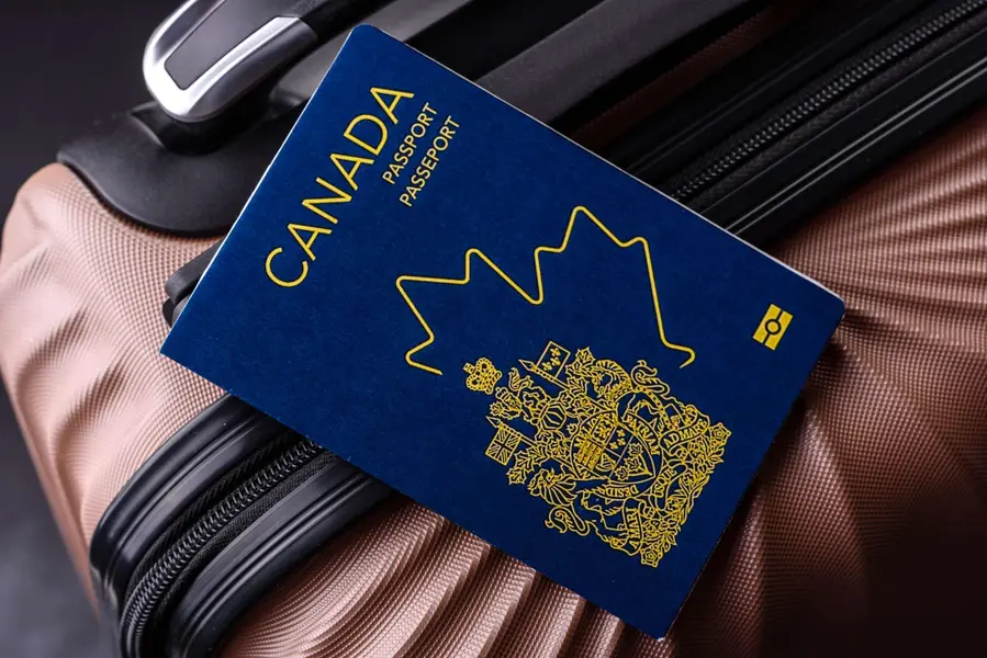Canadian passport on a pink suitcase